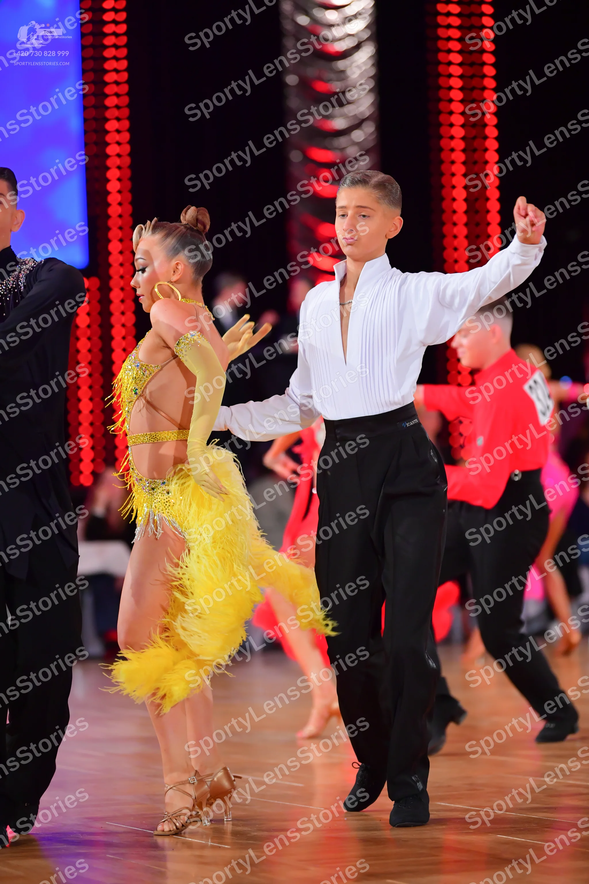 Dancesport competitor: Female dancer: yellow Latin dress with fringe, sequins, and nude mesh