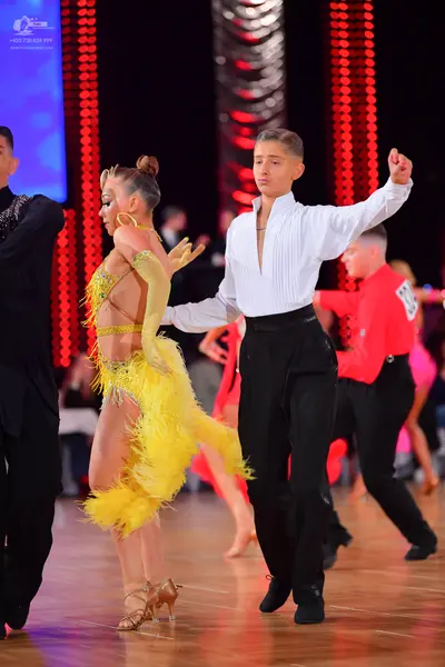 Dancesport competitor: Female dancer: yellow Latin dress with fringe, sequins, and nude mesh