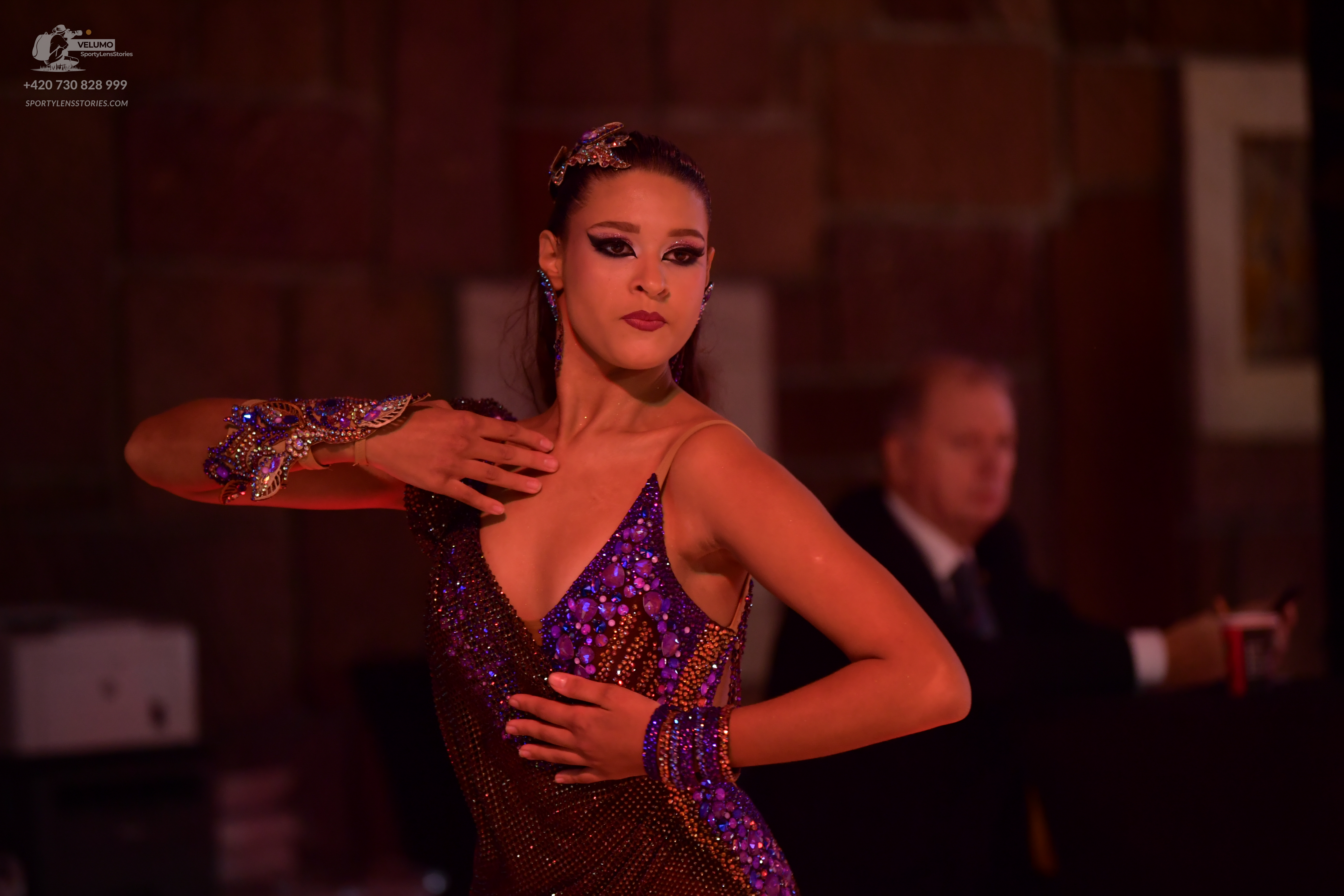 Dancesport competitor: Female dancer: dark purple sequined Latin dress with a deep V-neckline and match