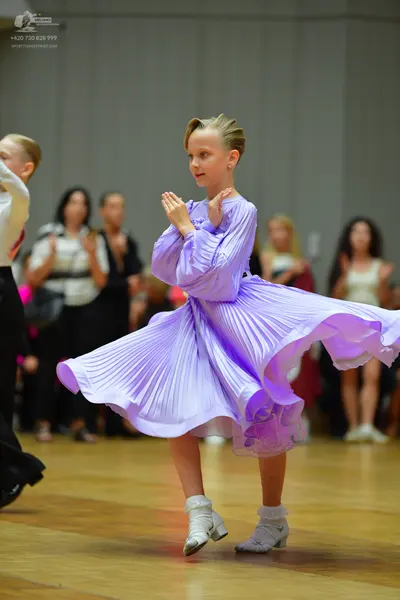 Dancesport competitor: Female dancer: light purple long-sleeved dress with a large, voluminous pleated 