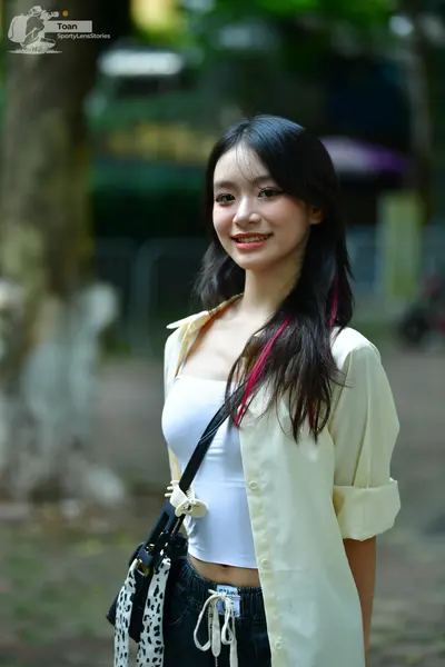 Dancesport competitor: The person is wearing a white top, an unbuttoned light yellow shirt, and dark pa