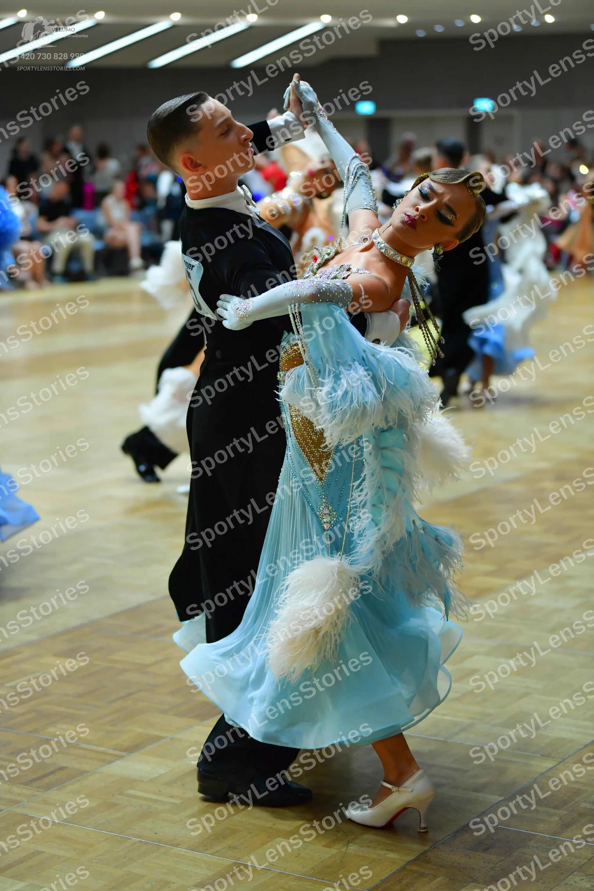 Dancesport competitor: Male dancer: black long-sleeved top with a white design on the shoulder and blac