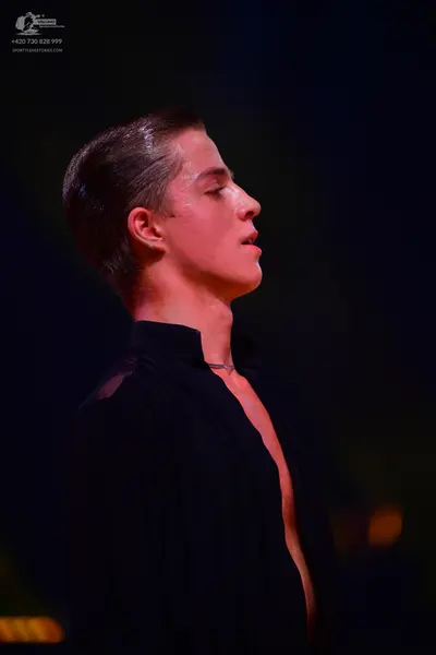 Dancesport competitor: Male dancer: black top with an open neckline