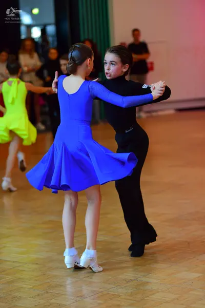 Dancesport competitor: Female dancer in blue: bright blue, long-sleeved latin dress with a flared skirt