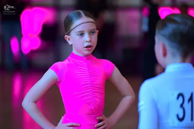 Dancesport competitor #31: Female dancer: bright pink, short-sleeved, high-neck top with ruching at the cen