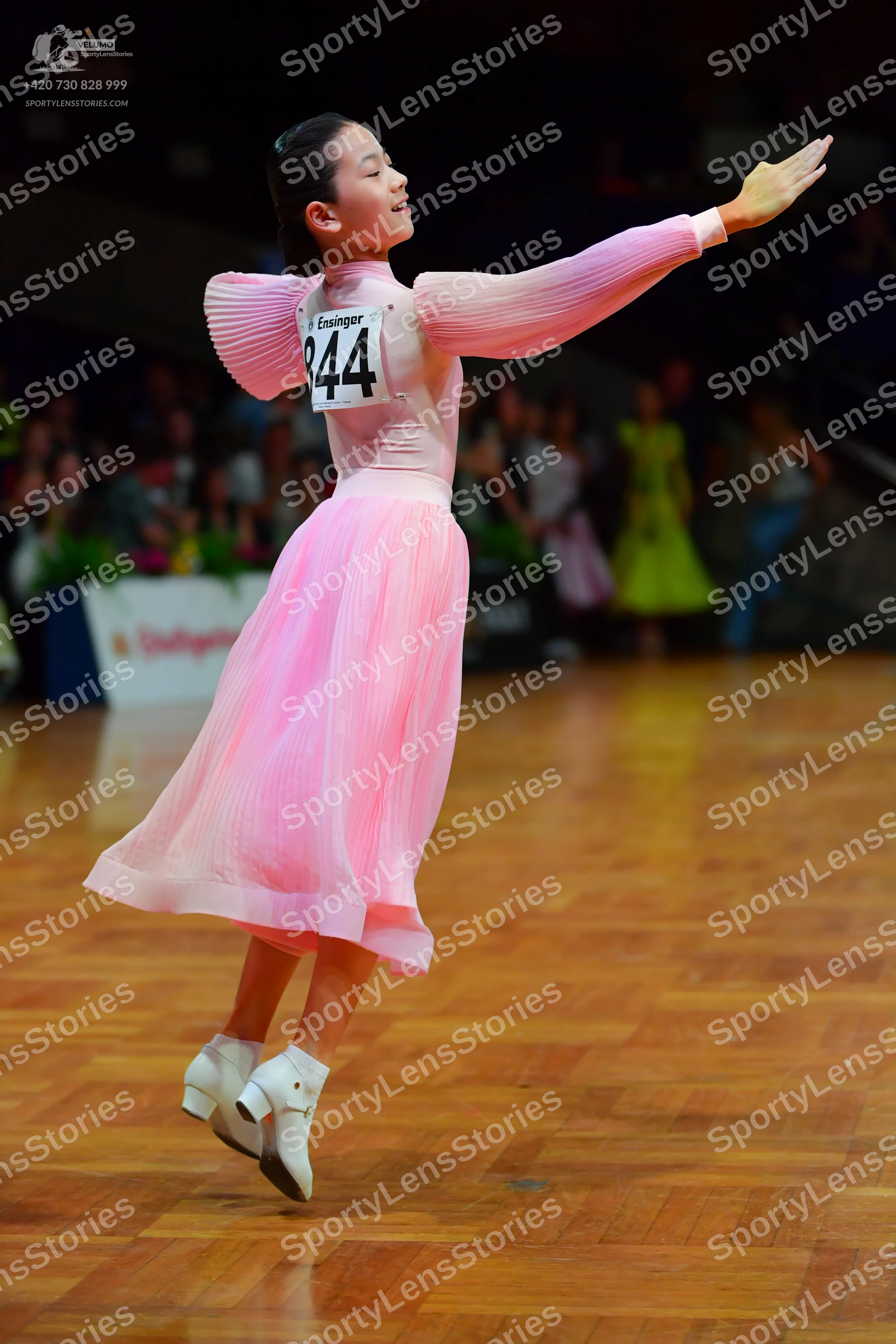 Dancesport competitor: Female dancer: light pink long-sleeved dress with a pleated bodice and a flowing