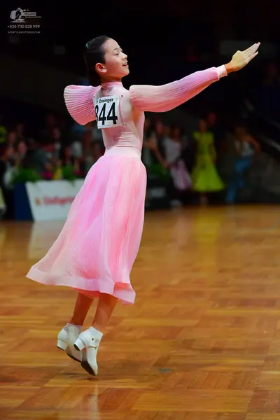 Dancesport competitor: Female dancer: light pink long-sleeved dress with a pleated bodice and a flowing