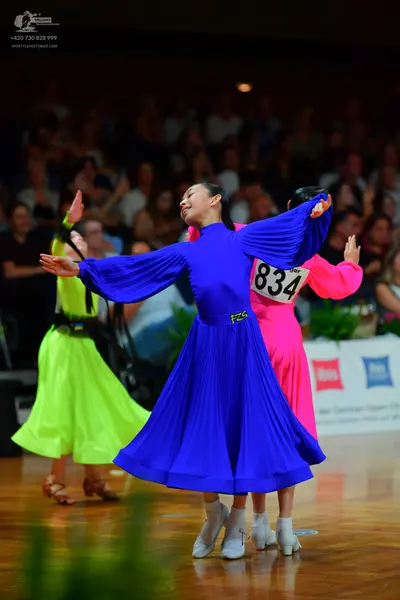 Dancesport competitor: Female dancer 1: blue long-sleeved dress with a pleated skirt