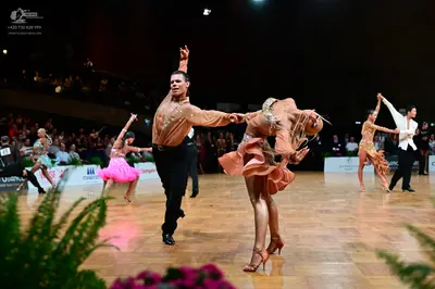 Dancesport competitor: Male dancer (center): champagne-colored long-sleeve shirt and black trousers