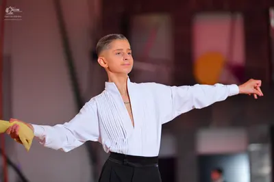 Dancesport competitor: Dancer: white long-sleeved shirt with a deep V-neck and vertical pleated detaili