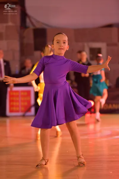 Dancesport competitor: Primary dancer: purple latin dress with short sleeves and a flared skirt