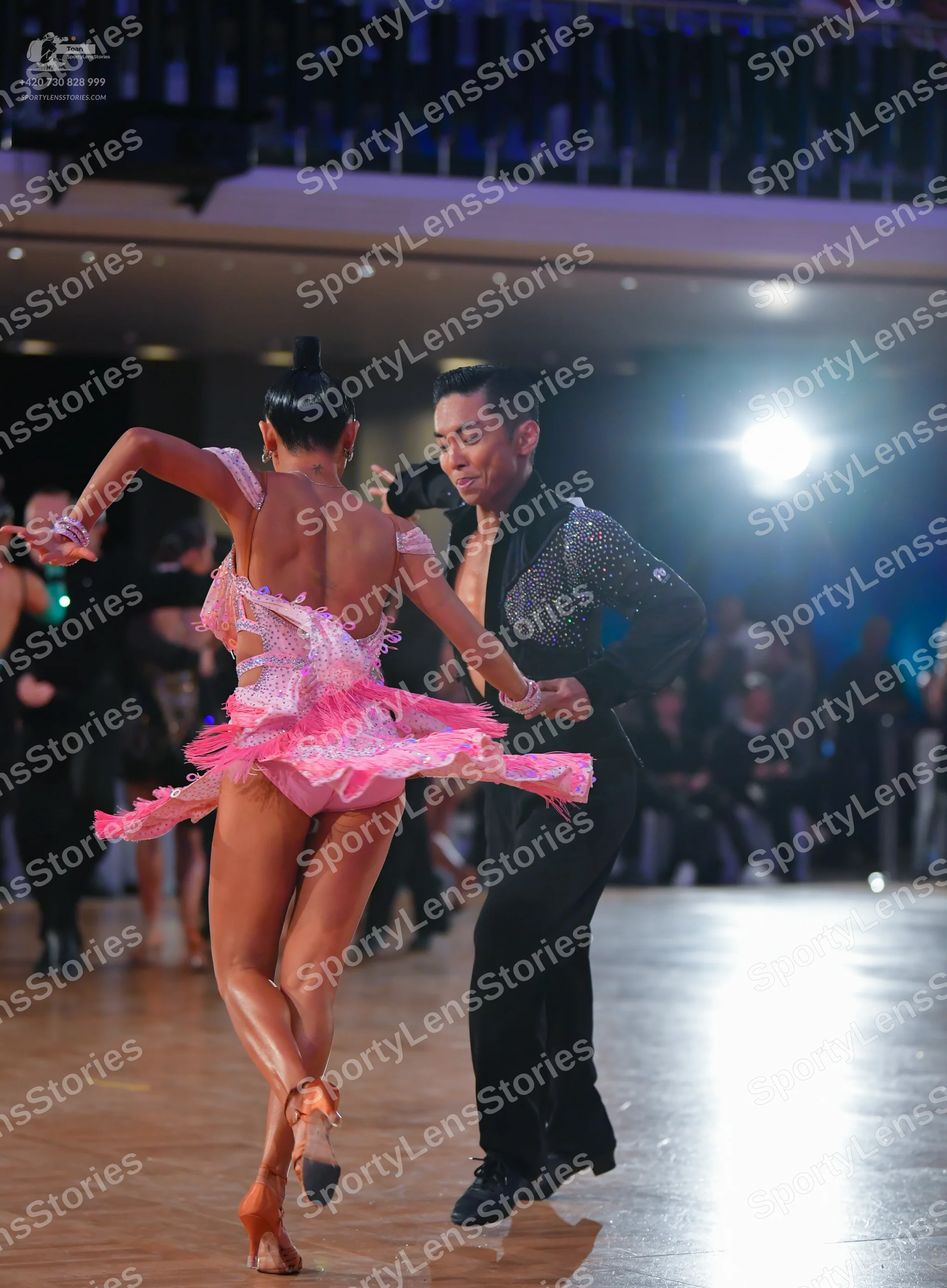 Dancesport competitor: Female dancer: pink sequined Latin dress with a short, flared, fringed skirt and