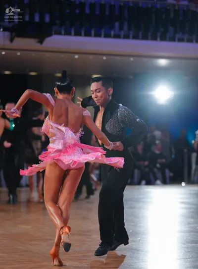 Dancesport competitor: Female dancer: pink sequined Latin dress with a short, flared, fringed skirt and