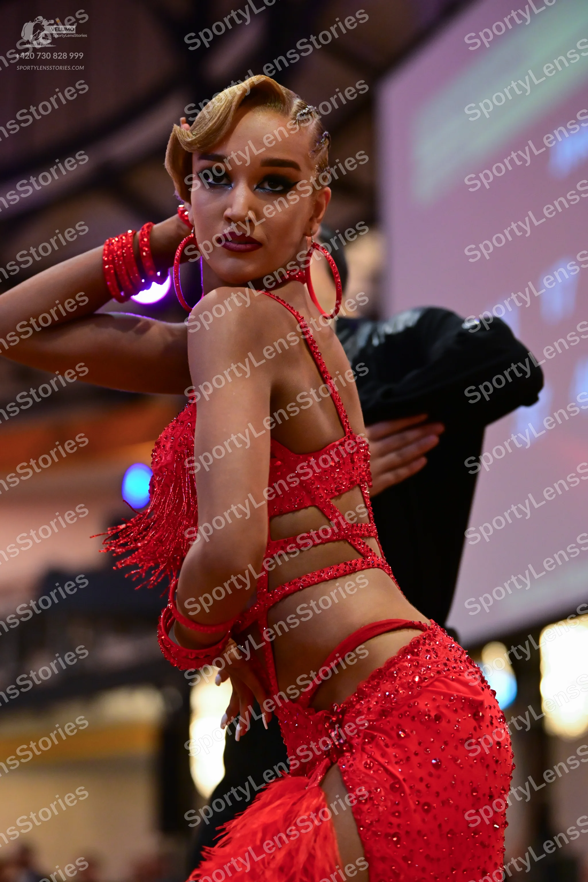 Dancesport competitor: Female dancer: red latin dress with fringe and rhinestones, featuring cut-outs, 
