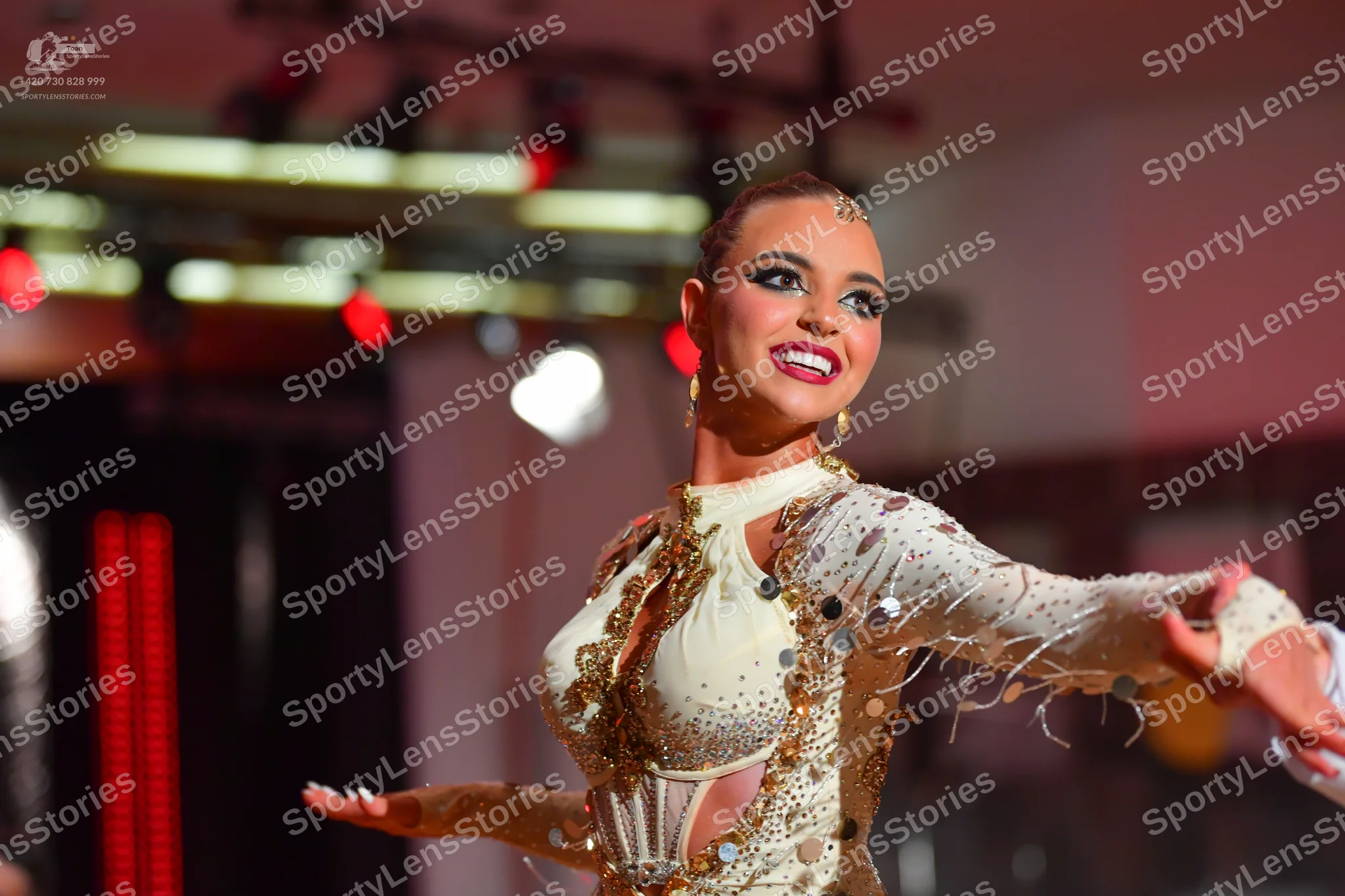 Dancesport competitor: Female dancer: cream-colored Latin dance dress heavily embellished with sequins