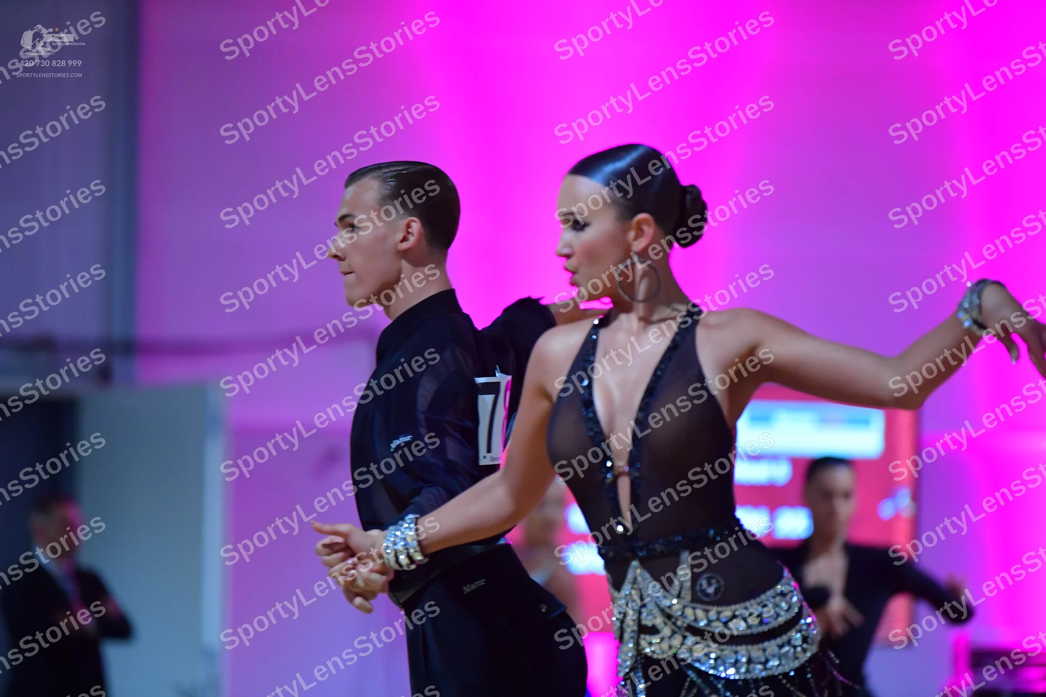 Dancesport competitor: Male dancer: black long-sleeved shirt, black trousers, and a sparkling silver cu