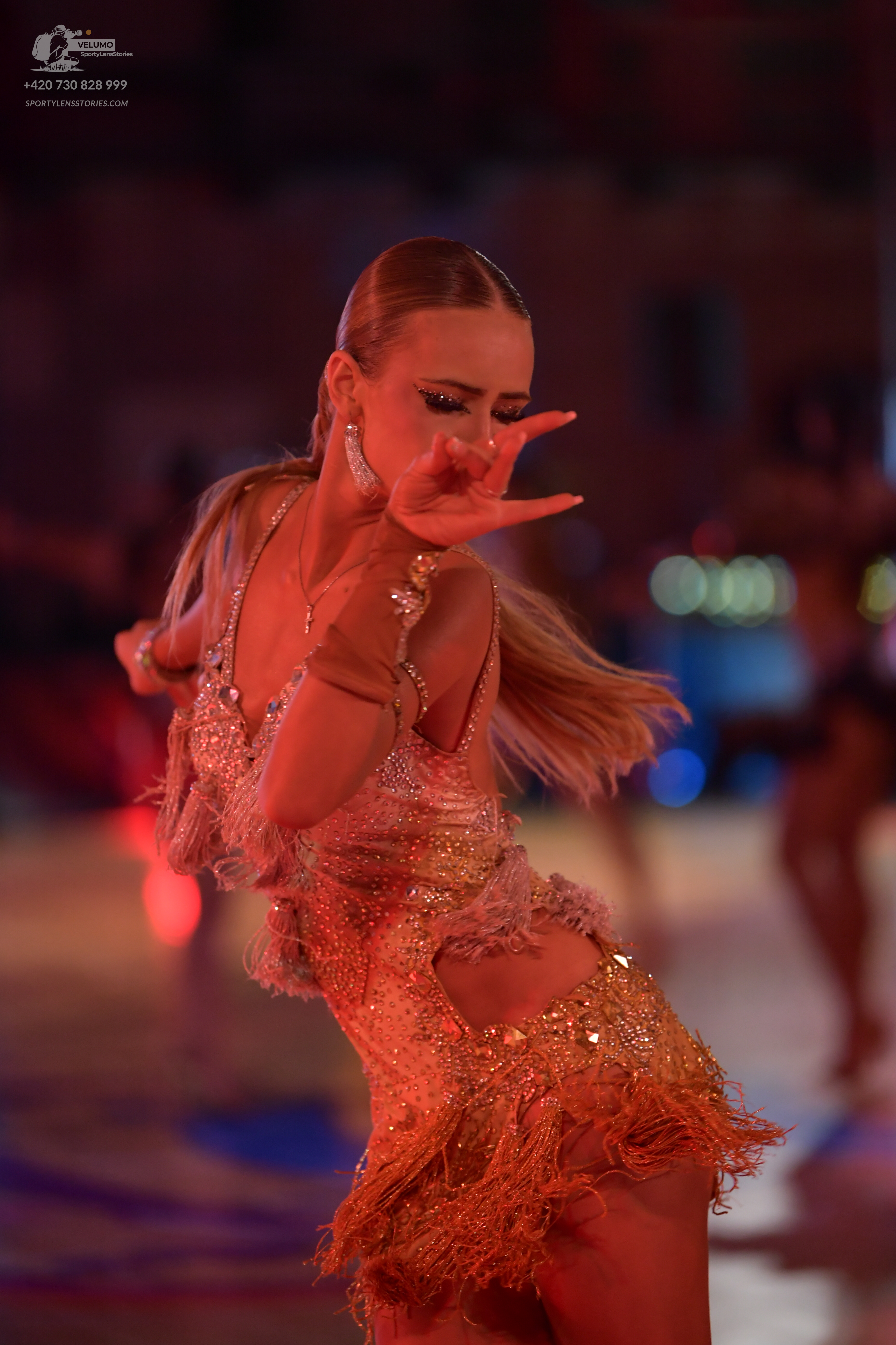 Dancesport competitor: Female dancer: gold sequined Latin dress with fringe and cutouts