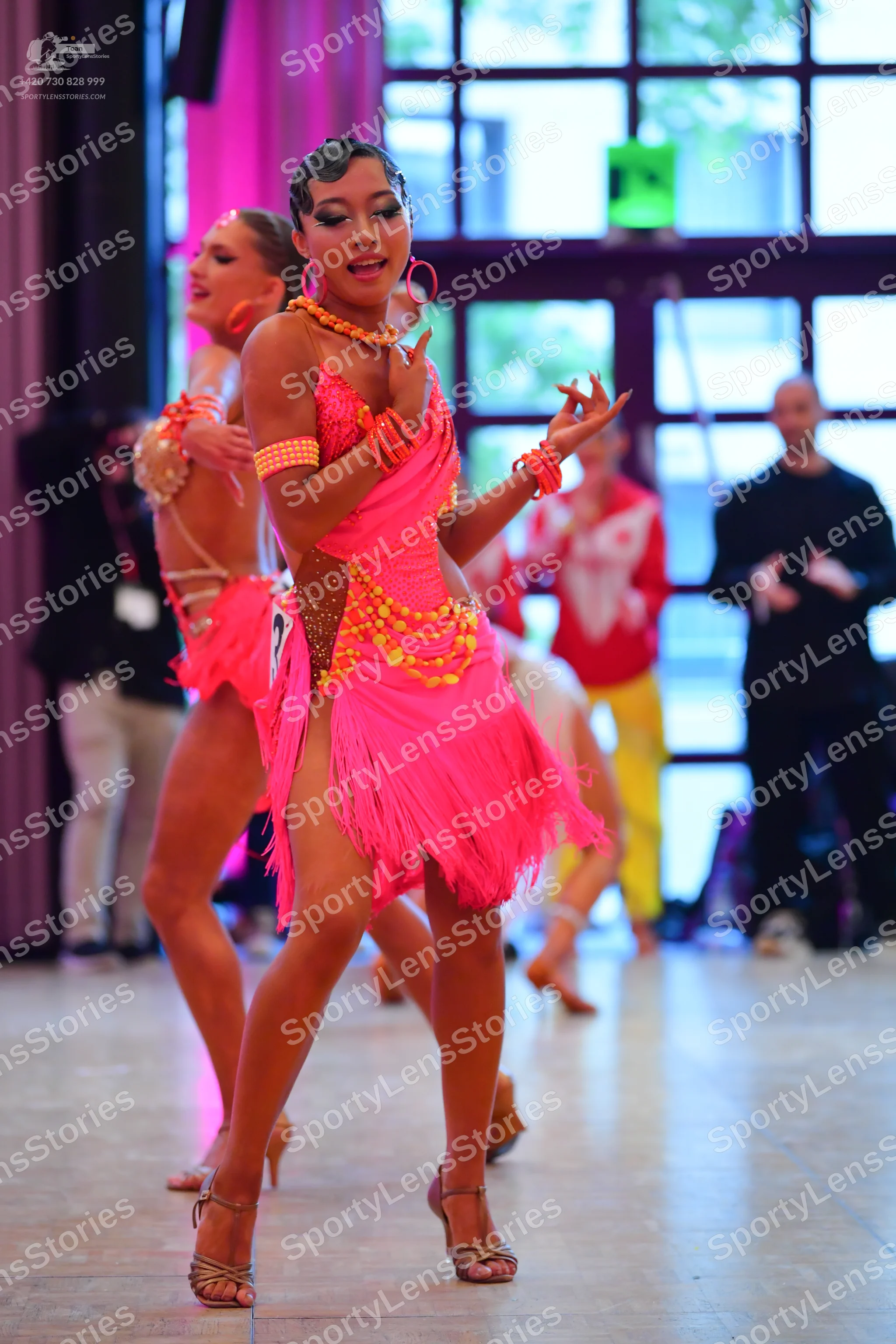 Dancesport competitor #73: Primary female dancer: bright pink Latin dress with a fringe skirt and gold/yell