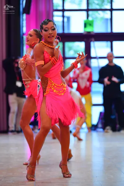 Dancesport competitor #73: Primary female dancer: bright pink Latin dress with a fringe skirt and gold/yell