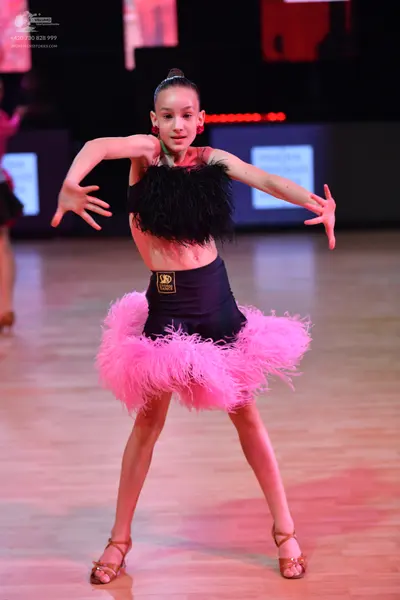 Dancesport competitor: Female dancer: black crop top with textured black fringe, black high-waisted sho