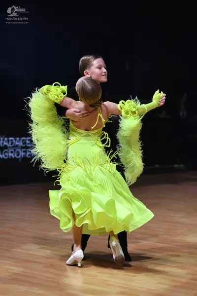 Dancesport competitor: Female dancer: lime green Latin dance dress with voluminous feathered/fringed sl