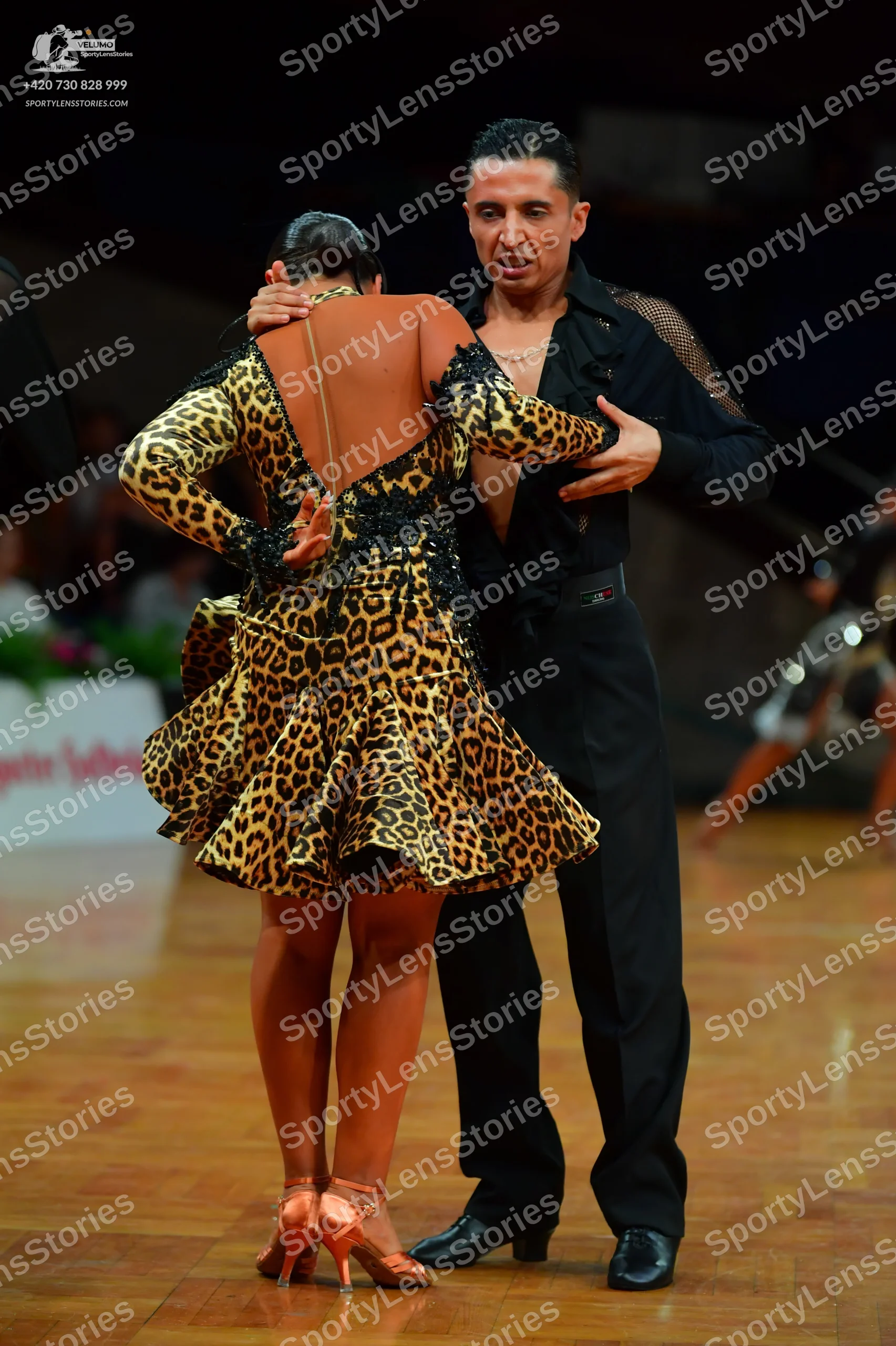 Dancesport competitor: Female dancer: leopard print latin dress with long sleeves and a flared skirt