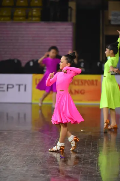 Dancesport competitor: Female dancer: bright pink long-sleeved latin dress