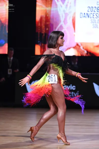 Dancesport competitor: Female dancer: colorful Latin dance dress with a black bodice and long, multi-co