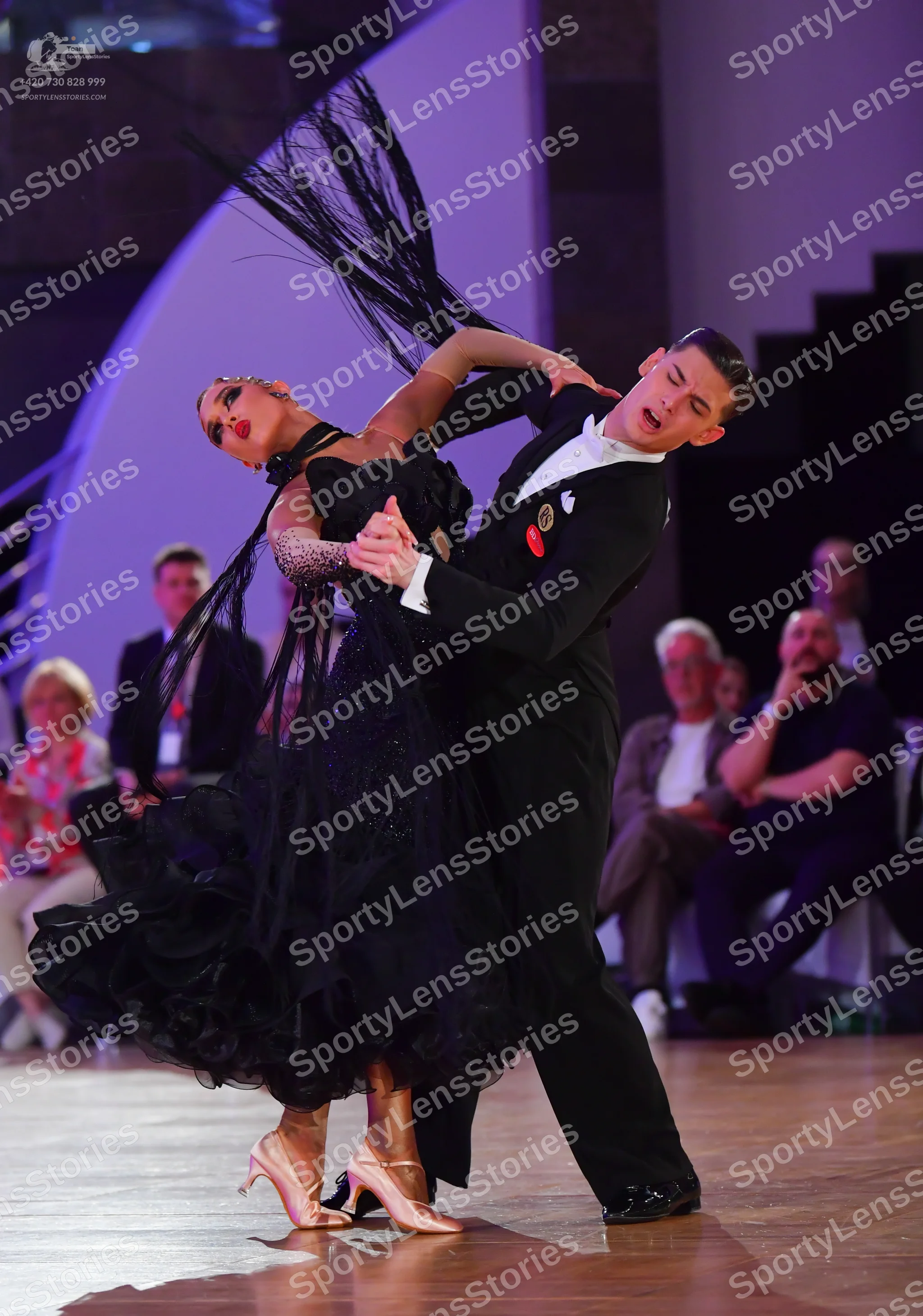 Dancesport competitor: Female dancer: voluminous black ballroom dress with ruffles and shimmering detai