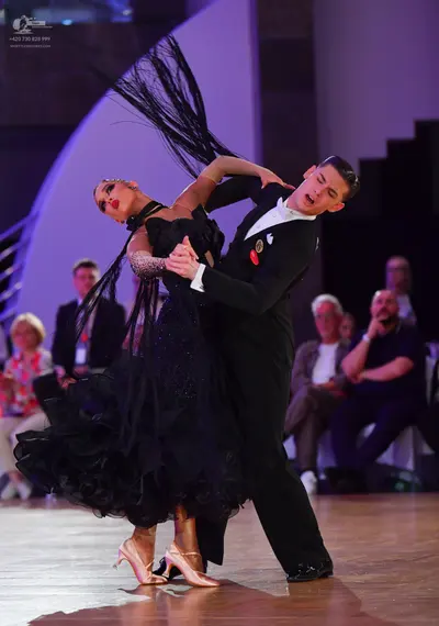Dancesport competitor: Female dancer: voluminous black ballroom dress with ruffles and shimmering detai