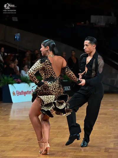 Dancesport competitor: Female dancer: leopard print latin dress with long sleeves, an open back, and a 