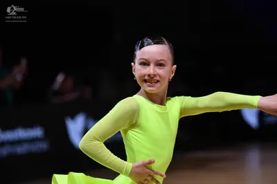 Dancesport competitor: Female dancer: neon yellow long-sleeved latin dress made of a stretchy matte fab