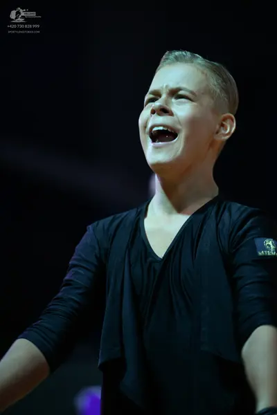 Dancesport competitor: Male dancer: black long-sleeved top with draped fabric