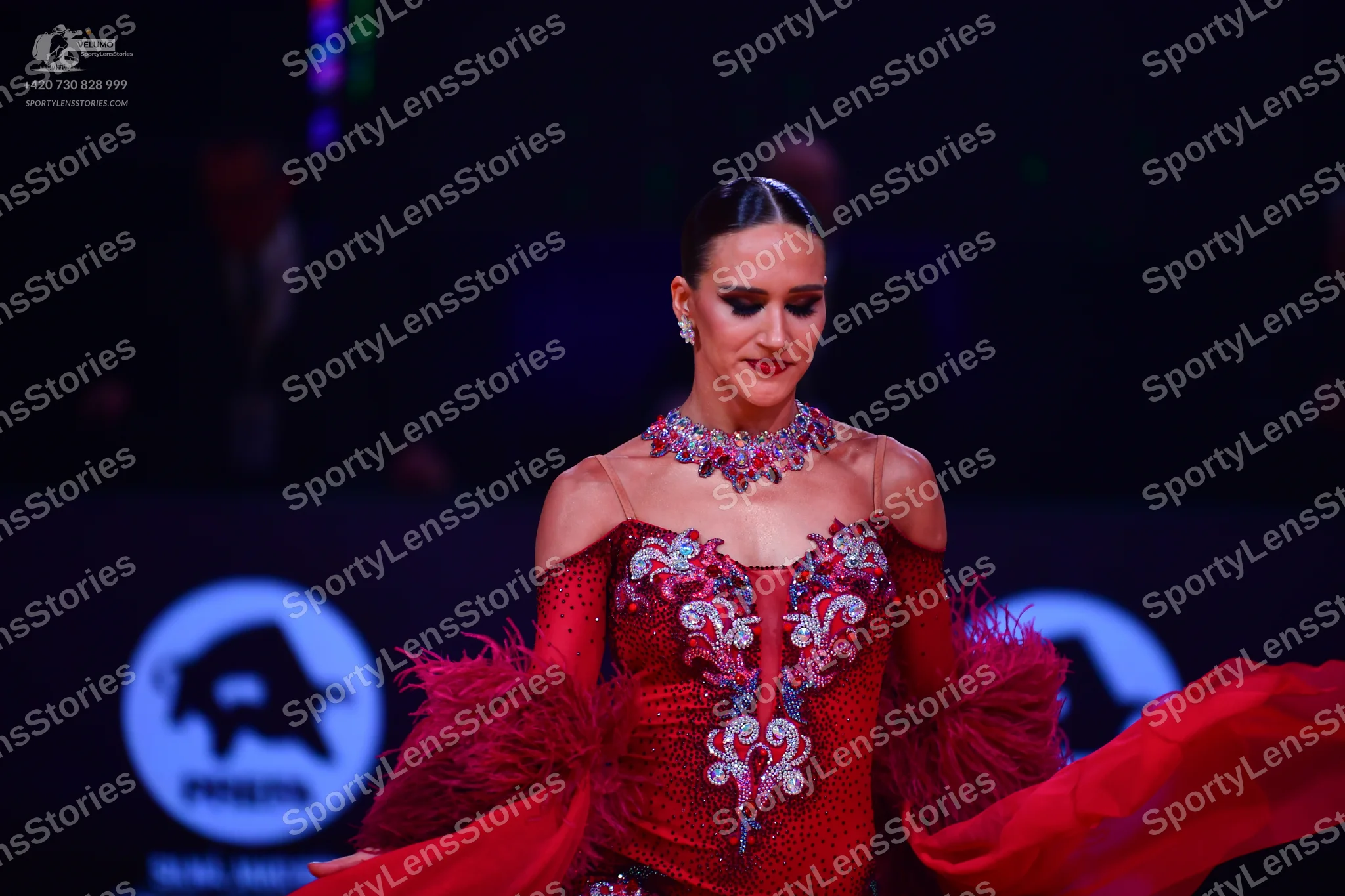 Dancesport competitor: Female dancer: red Latin dress with intricate silver and white crystal embellish