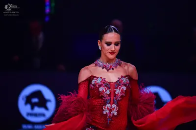 Dancesport competitor: Female dancer: red Latin dress with intricate silver and white crystal embellish