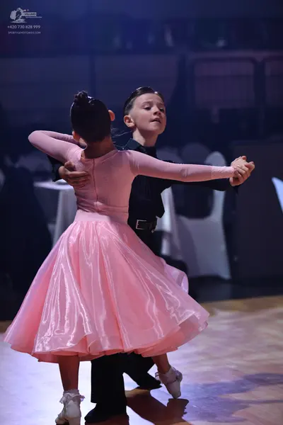 Dancesport competitor: Female dancer: pink ballroom dress with long sleeves and a voluminous satin skir
