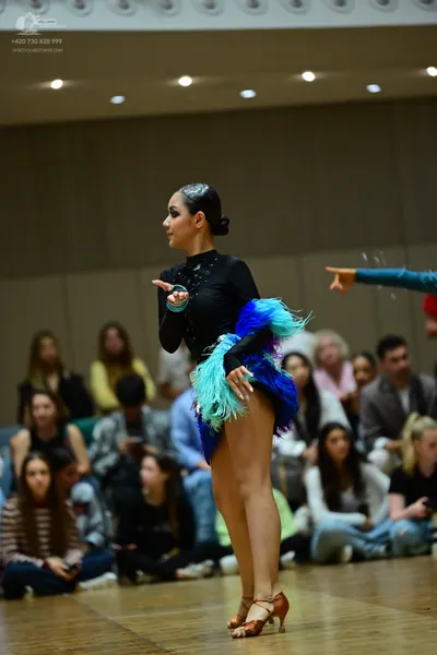 Dancesport competitor: Female dancer: black long-sleeved Latin dress with a voluminous skirt made of bl