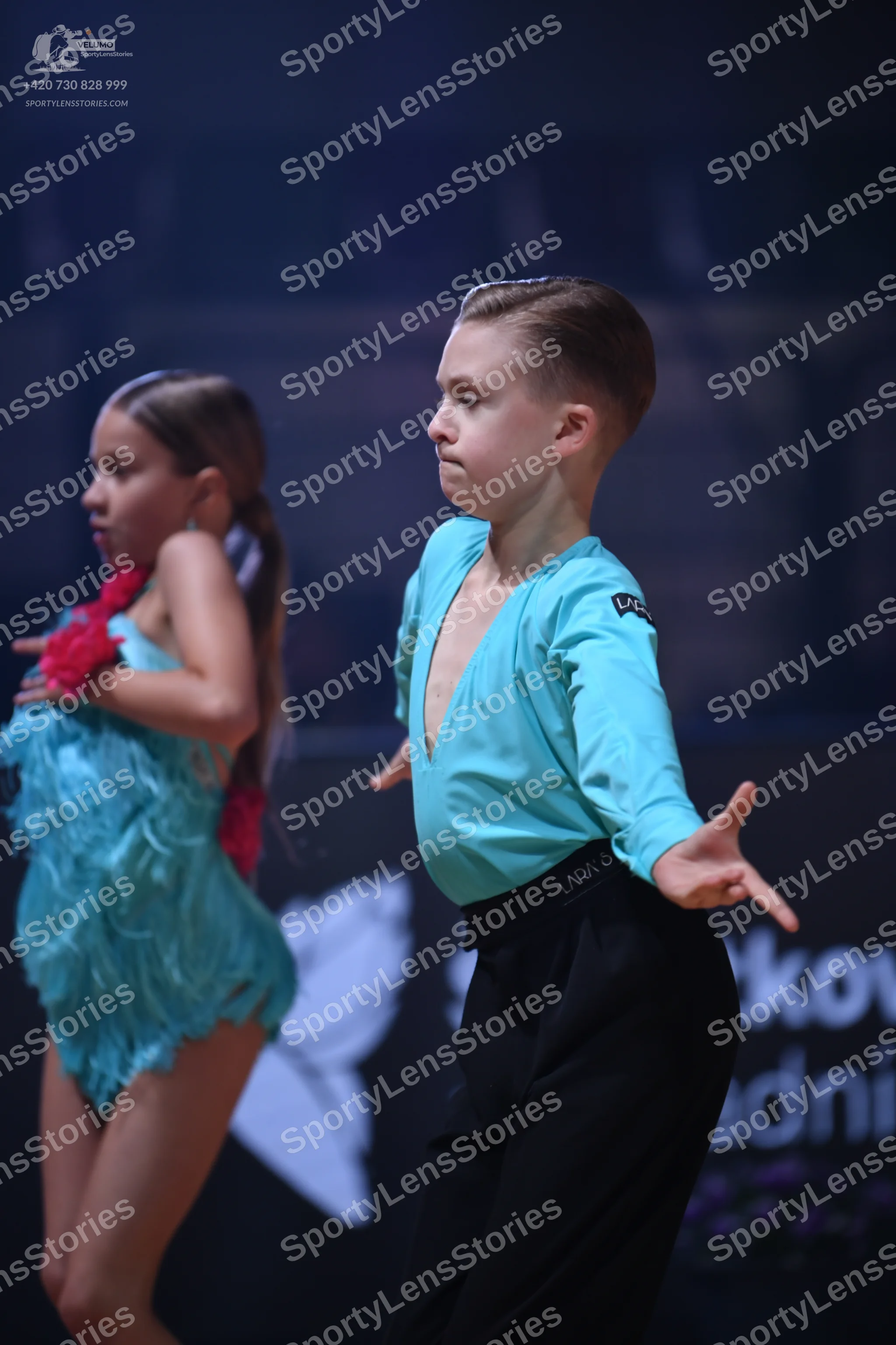 Dancesport competitor: Male dancer: light blue long-sleeved shirt with a deep V-neck and black trousers