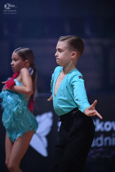 Dancesport competitor: Male dancer: light blue long-sleeved shirt with a deep V-neck and black trousers
