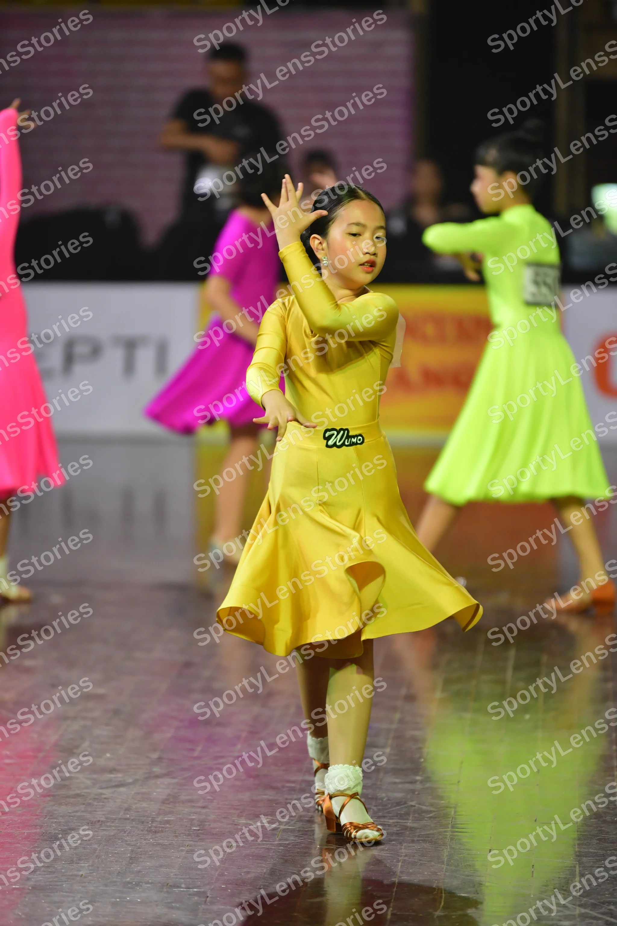 Dancesport competitor: Female dancer: yellow latin dress with long sleeves and smooth fabric; Female da
