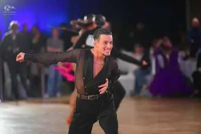 Dancesport competitor: Male dancer: black long-sleeved Latin shirt with a sheer mesh panel on the chest