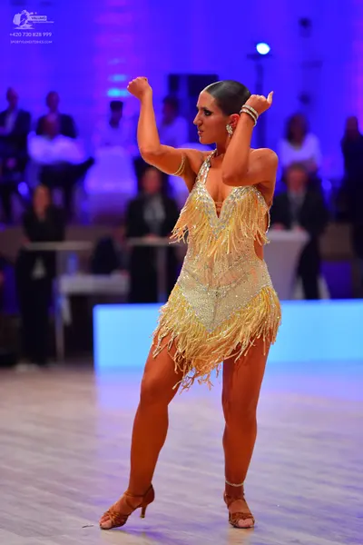 Dancesport competitor: Female dancer: light gold/champagne sequined Latin dress with fringe