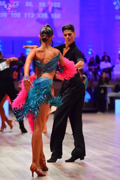 Dancesport competitor: Female dancer: teal sequin two-piece latin outfit with pink fringe