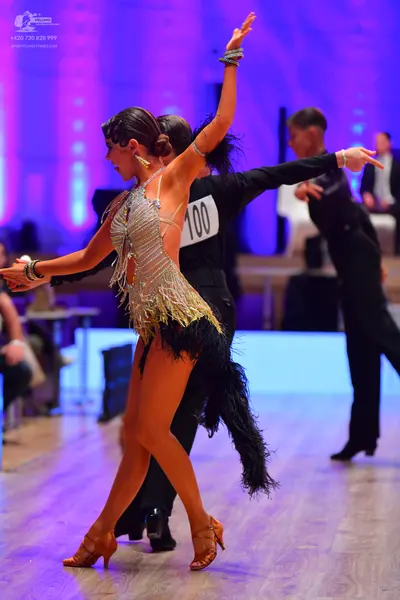 Dancesport competitor: Female dancer: gold sequin and fringe latin dress with gold accessories