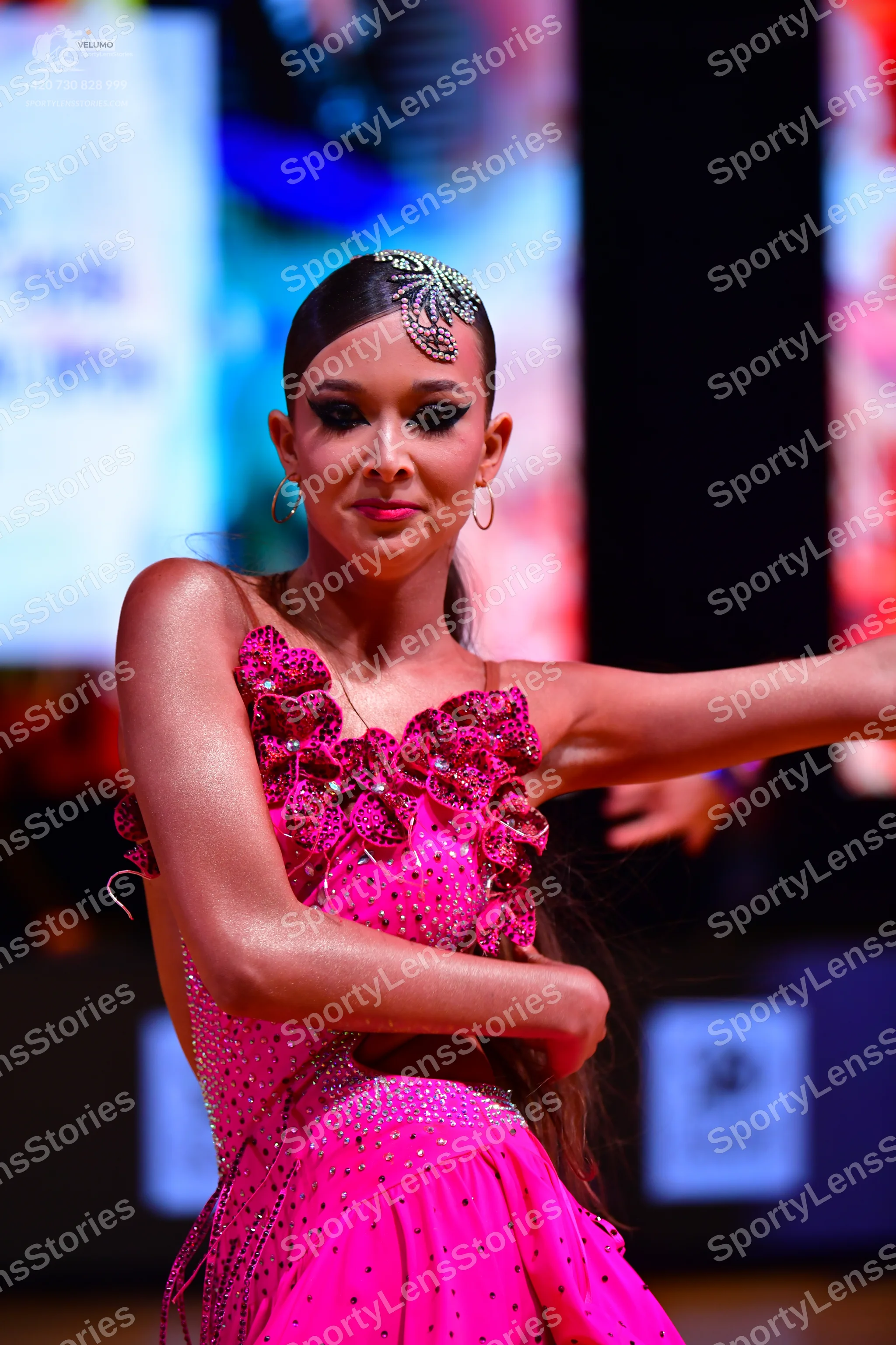 Dancesport competitor: Female dancer: bright pink latin dress decorated with rhinestones and large 3D f