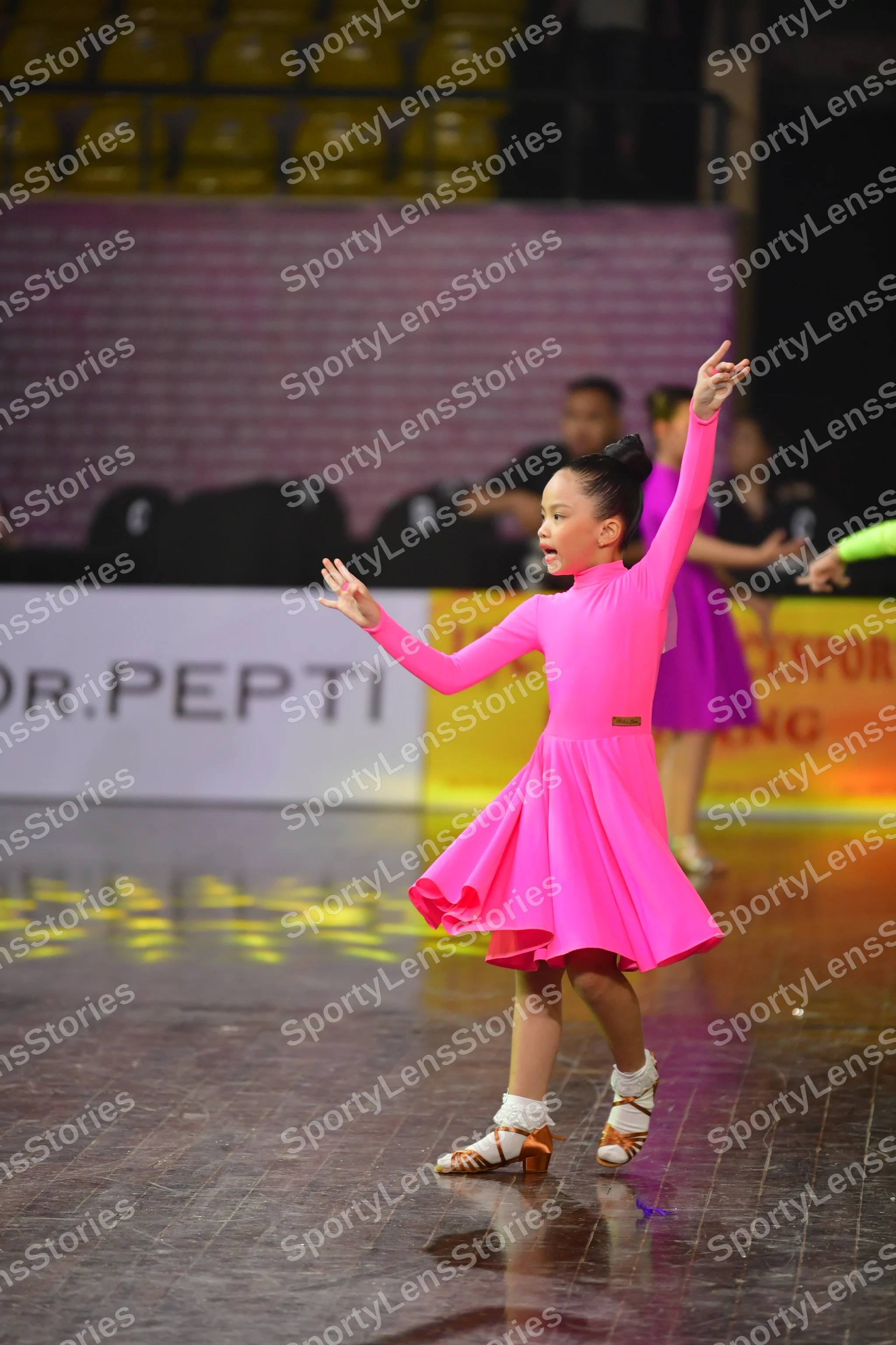 Dancesport competitor: Female dancer 1: pink long-sleeved latin dress
