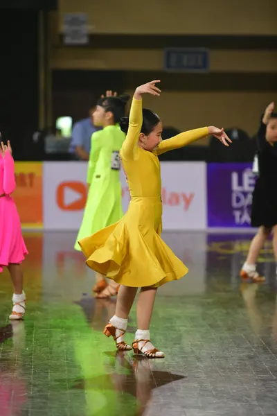 Dancesport competitor: Female dancer: yellow latin dress with long sleeves