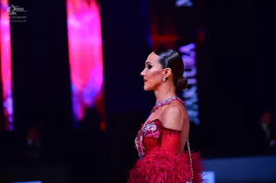 Dancesport competitor: Female dancer: red Latin dress with red feathers and silver/white embellishments