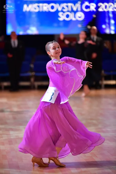 Dancesport competitor: Female dancer: long, flowing, bright purple ballroom dress with wide bell sleeve