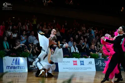 Dancesport competitor: Female dancer (left): white and silver ballroom gown with a large, voluminous sk